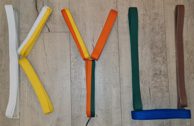 Farbige Gürtel bilden das Wort Kyu